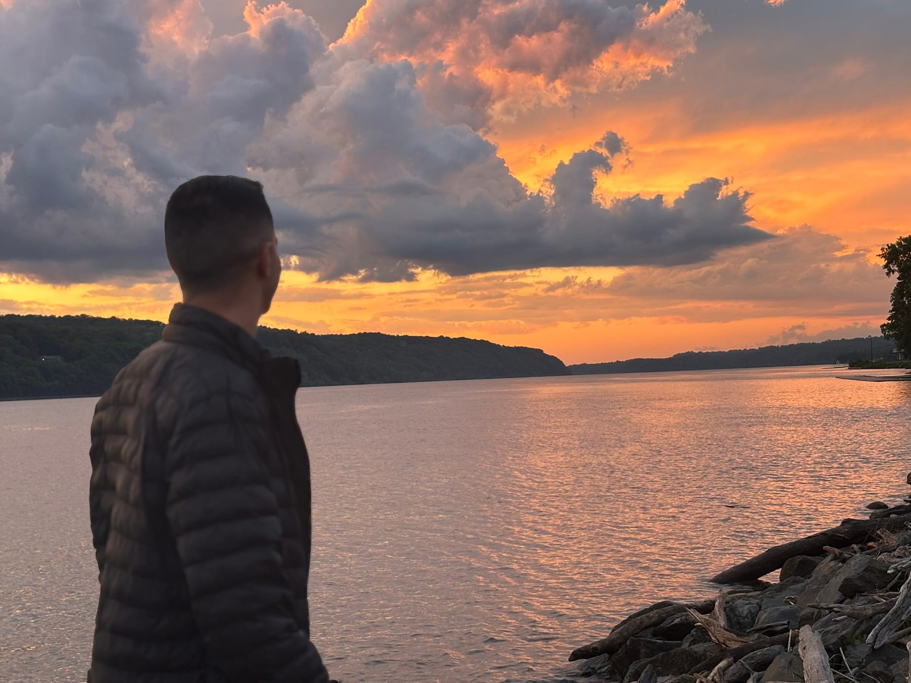 Mathew Watson looking out over the Hudson River at sunset